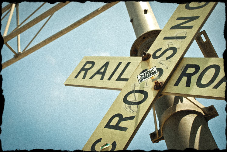 Railroad crossing sign with sticker in the middle