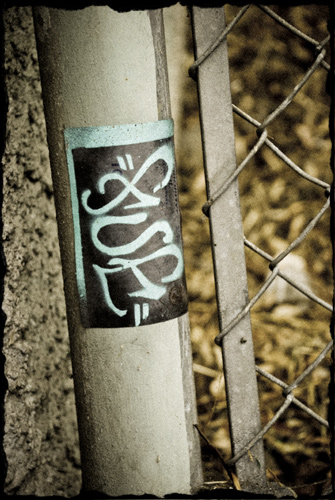 Sticker on side of pole of a chain link fence.
