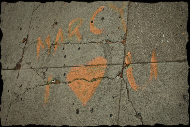 Painted on the sidewalk are the words: Marcy, I love you
