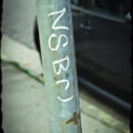 The letters "nsbr" graffitied on sign pole