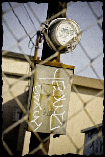 Business electrical meter on telephone pole with graffiti on it