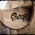 Driveway mirror with "soor" spray painted on it