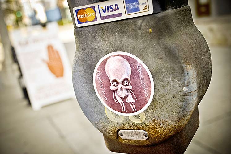 Sticker on parking meter with psychic sign in background